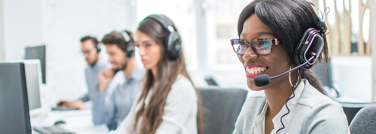 Employees at computers wearing headsets